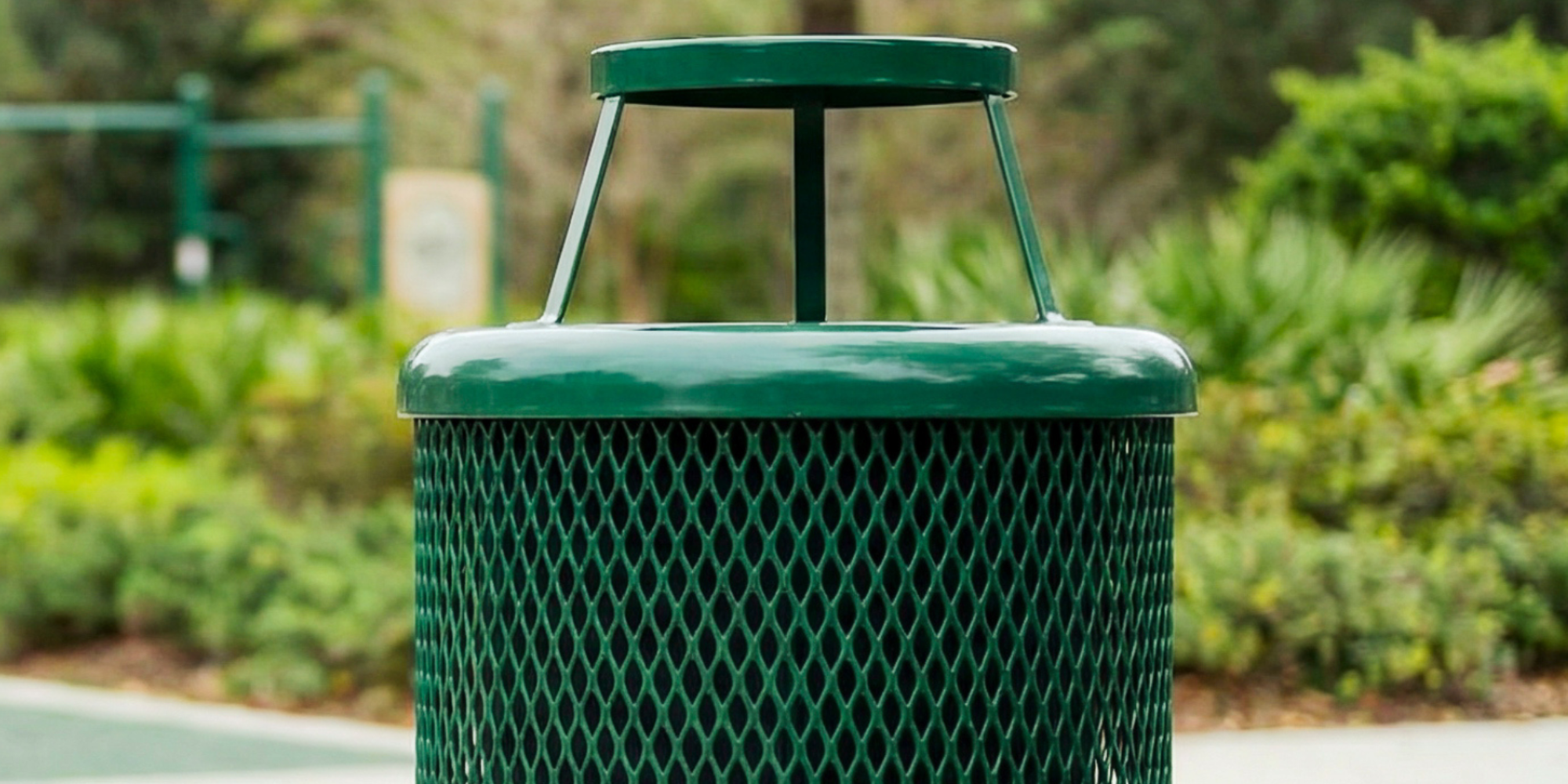 Green commercial outdoor metal trash receptacle with bonnet lid and expanded steel design for durable weather-resistant waste collection in parks and public spaces