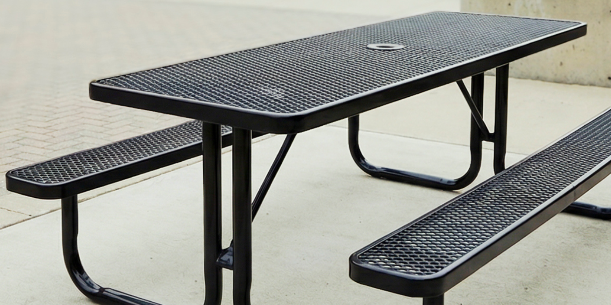 Black rectangular expanded metal picnic table with reinforced steel frame and durable outdoor finish for commercial seating areas