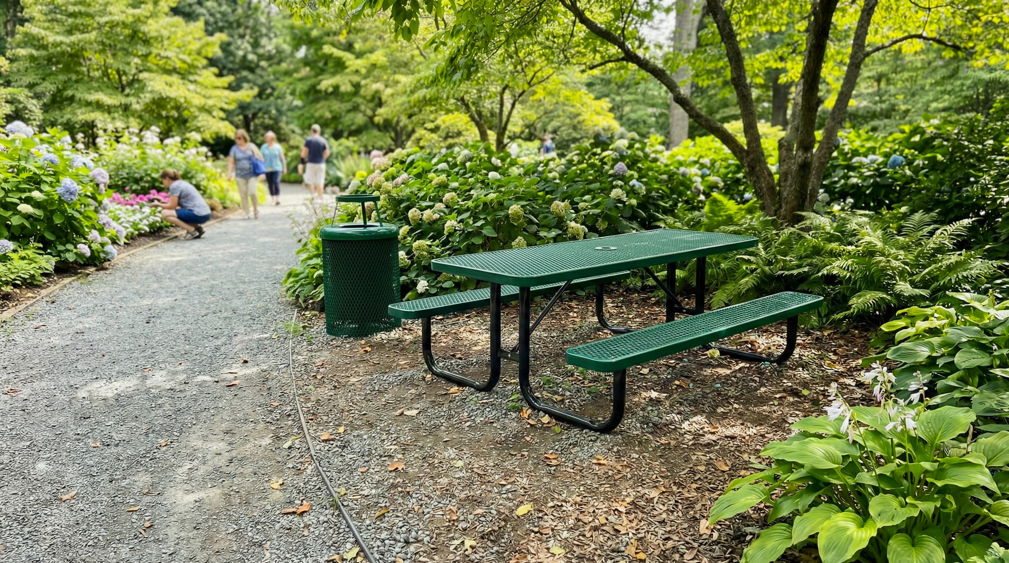 Green 6 ft rectangular expanded metal picnic table with heavy-duty steel frame and coordinating commercial outdoor trash receptacle