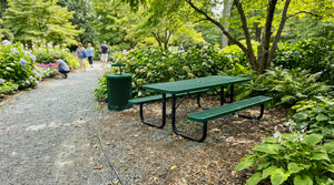 Green 6 ft rectangular expanded metal picnic table with heavy-duty steel frame and coordinating commercial outdoor trash receptacle