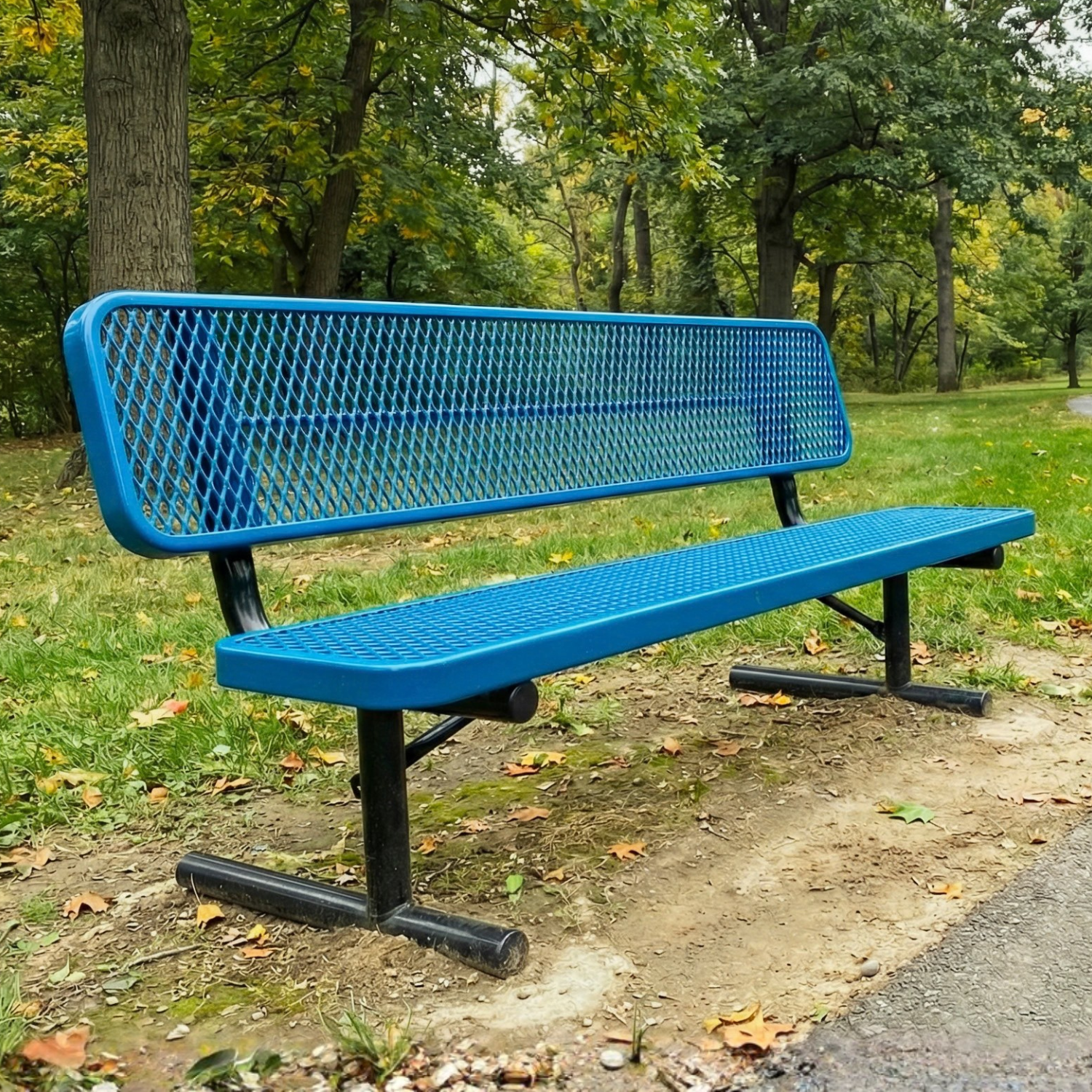 Blue metal bench in a park setting with trees and grass.