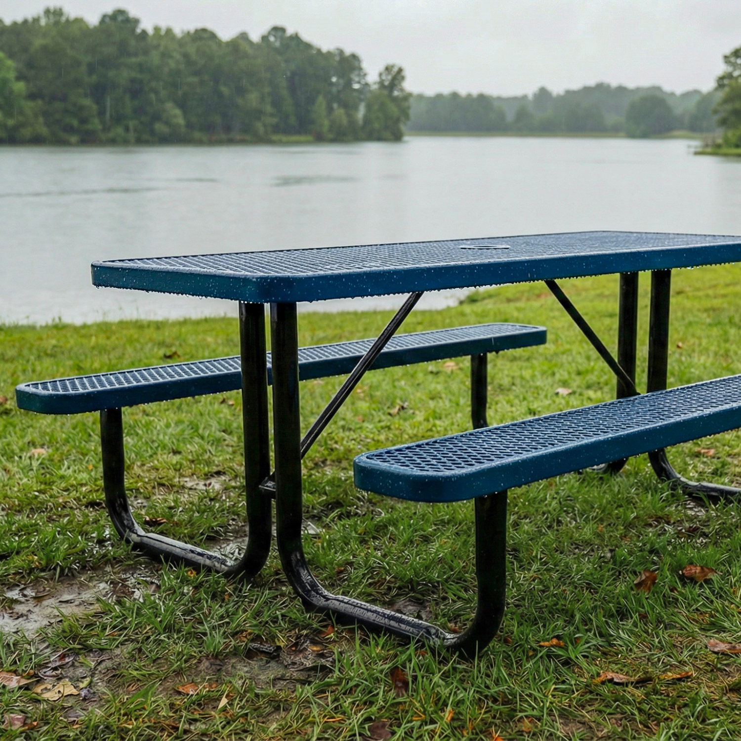 Blue picnic table in a park with a lake in the background