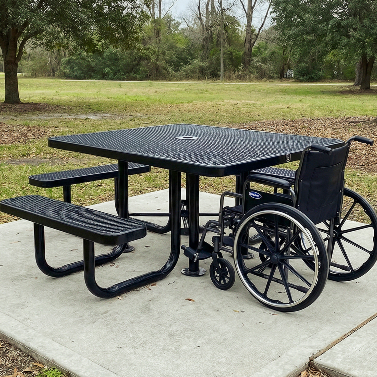 Black wheelchair-accessible picnic table with a wheelchair in a park setting.