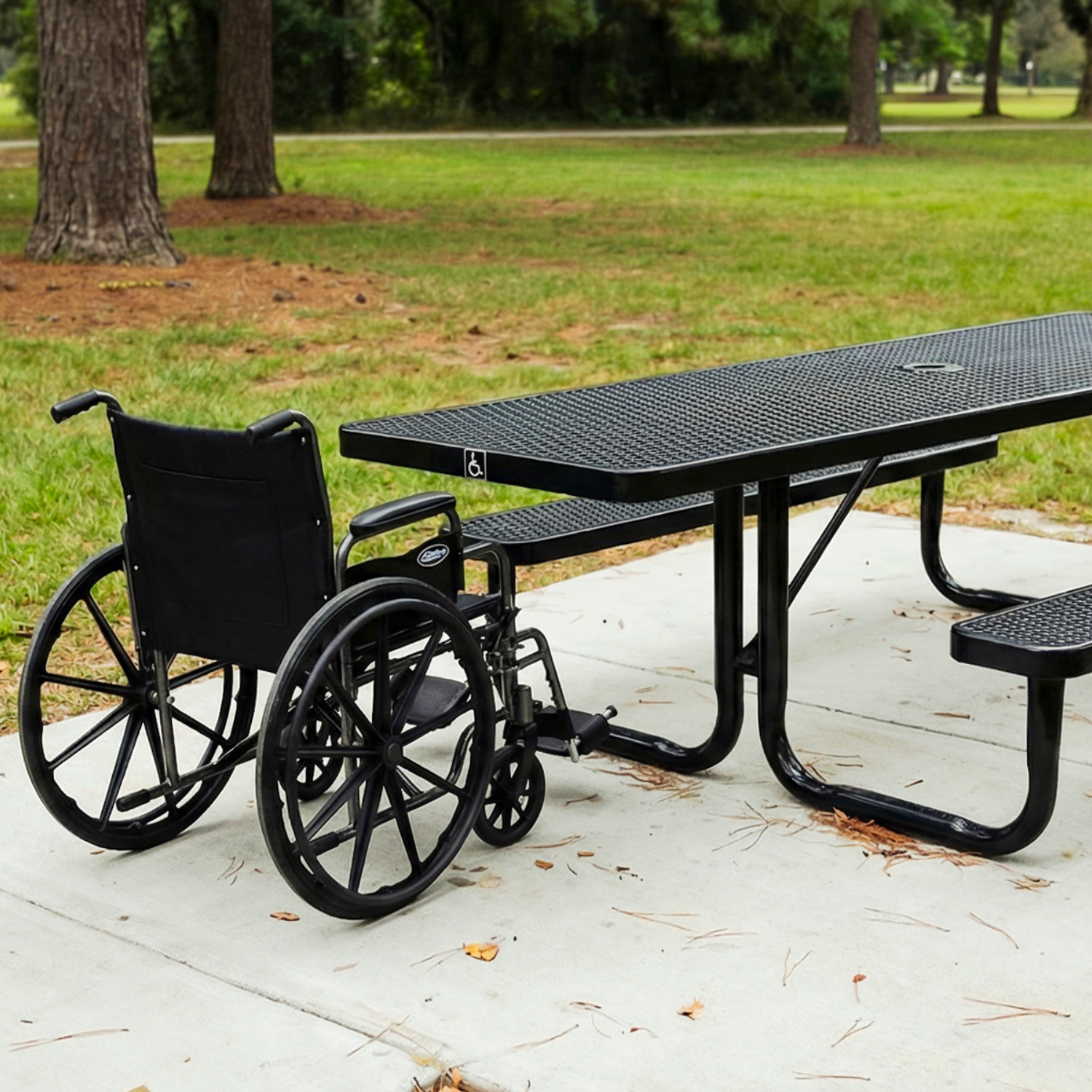 Wheelchair next to a black metal picnic table in a park setting