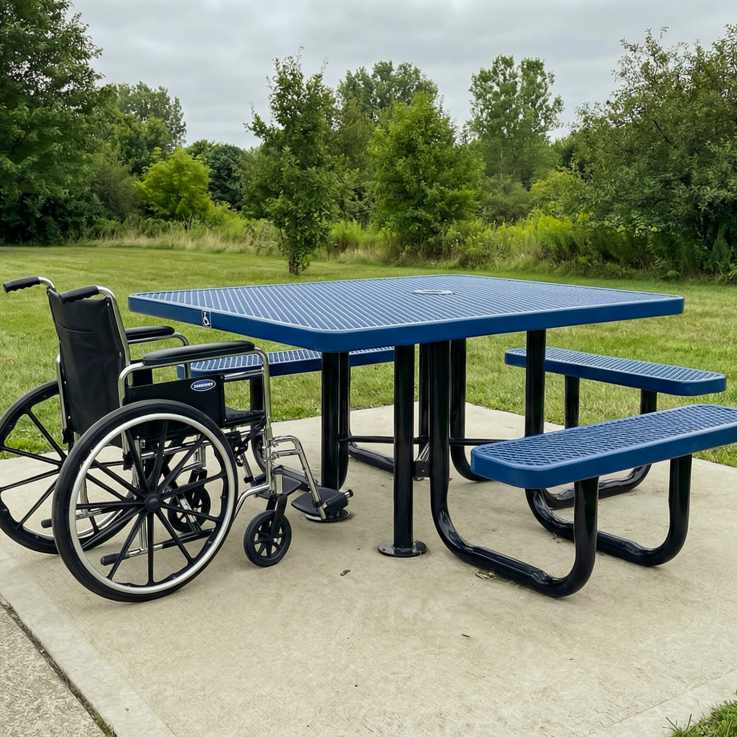 Blue picnic table with black wheelchair and benches in a park setting