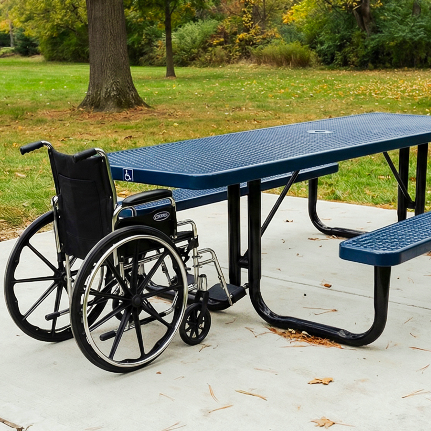 Wheelchair next to a blue ADA picnic table in a park setting