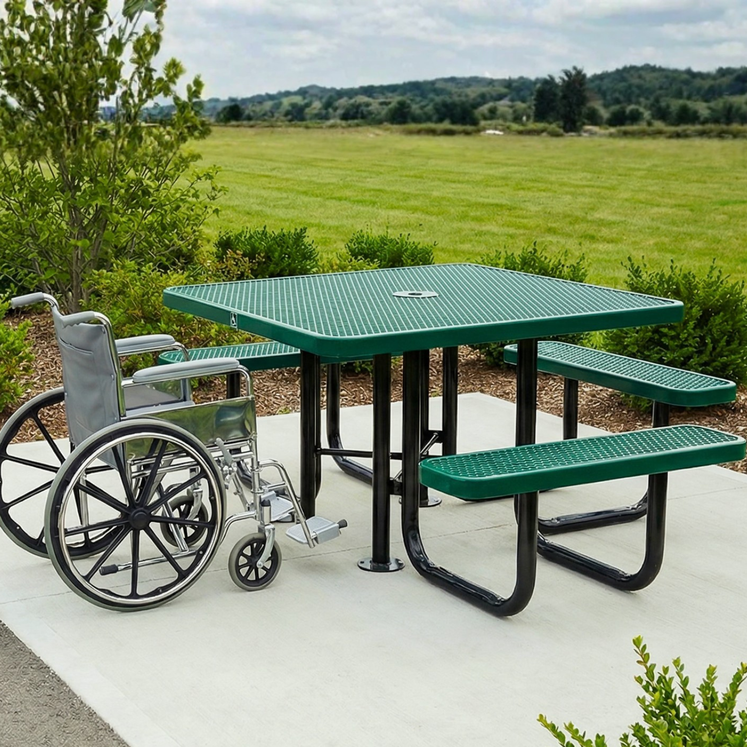 Green picnic table with wheelchair accessibility features in a park setting