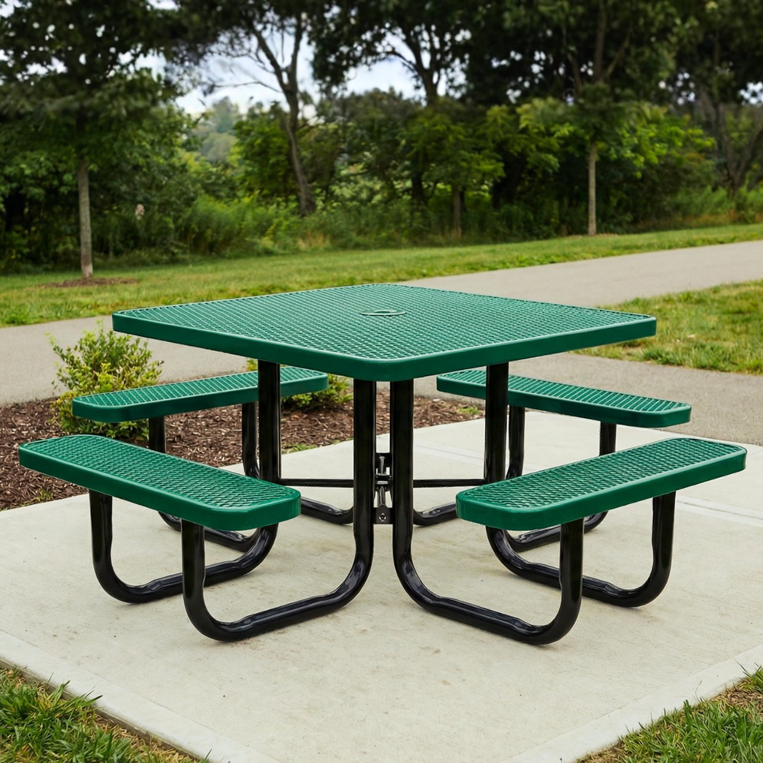 Green square picnic table with benches in a park setting