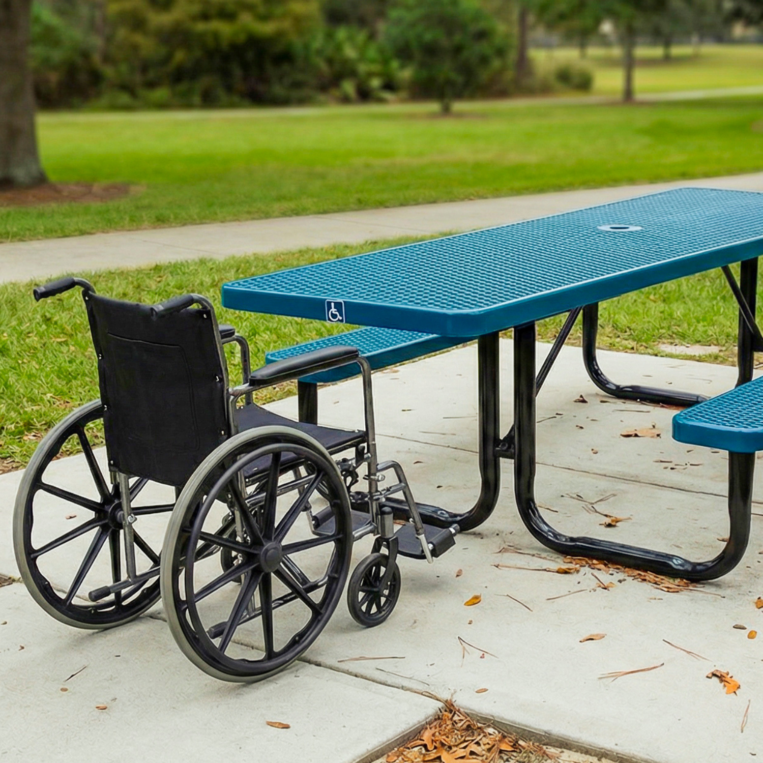 Wheelchair next to an ADA blue picnic table in a park setting