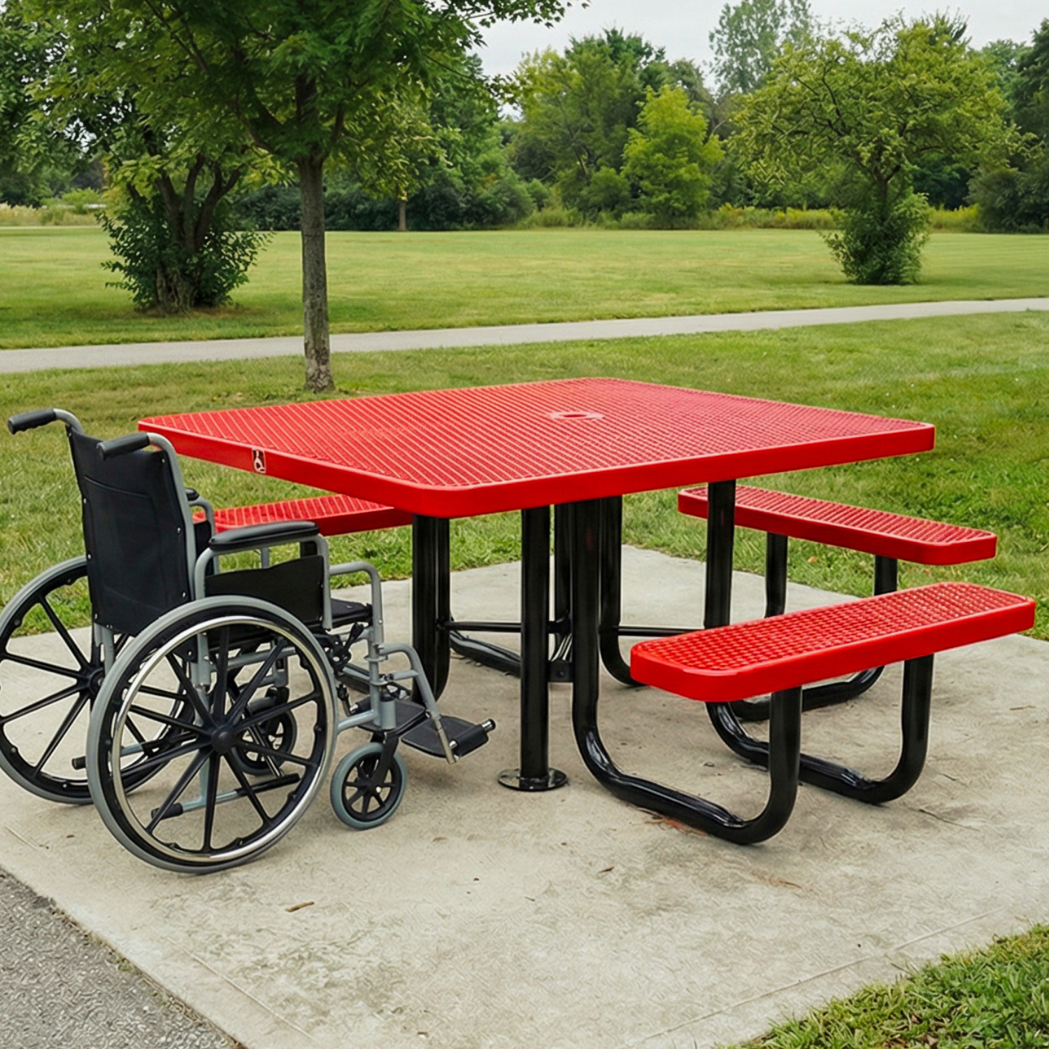 Red picnic table with black wheelchair-accessible design in a park setting
