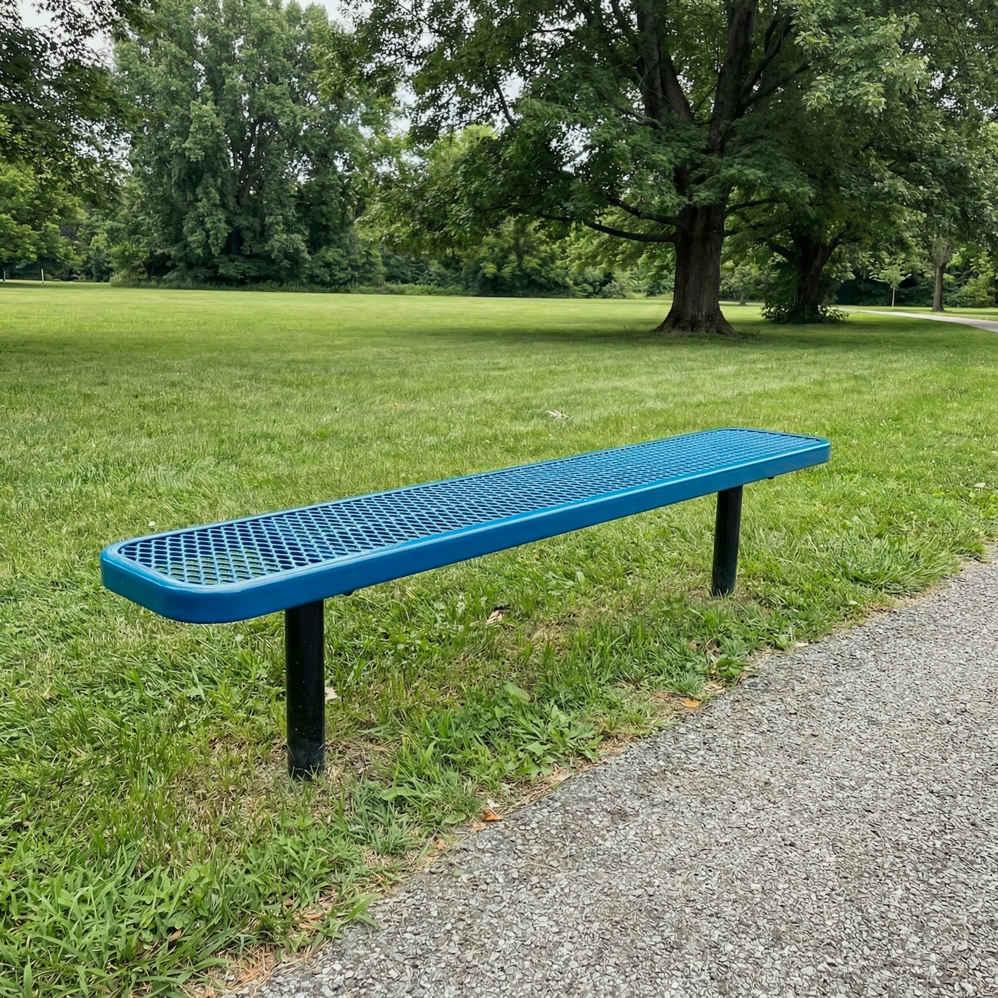Blue bench on a grassy area with trees in the background